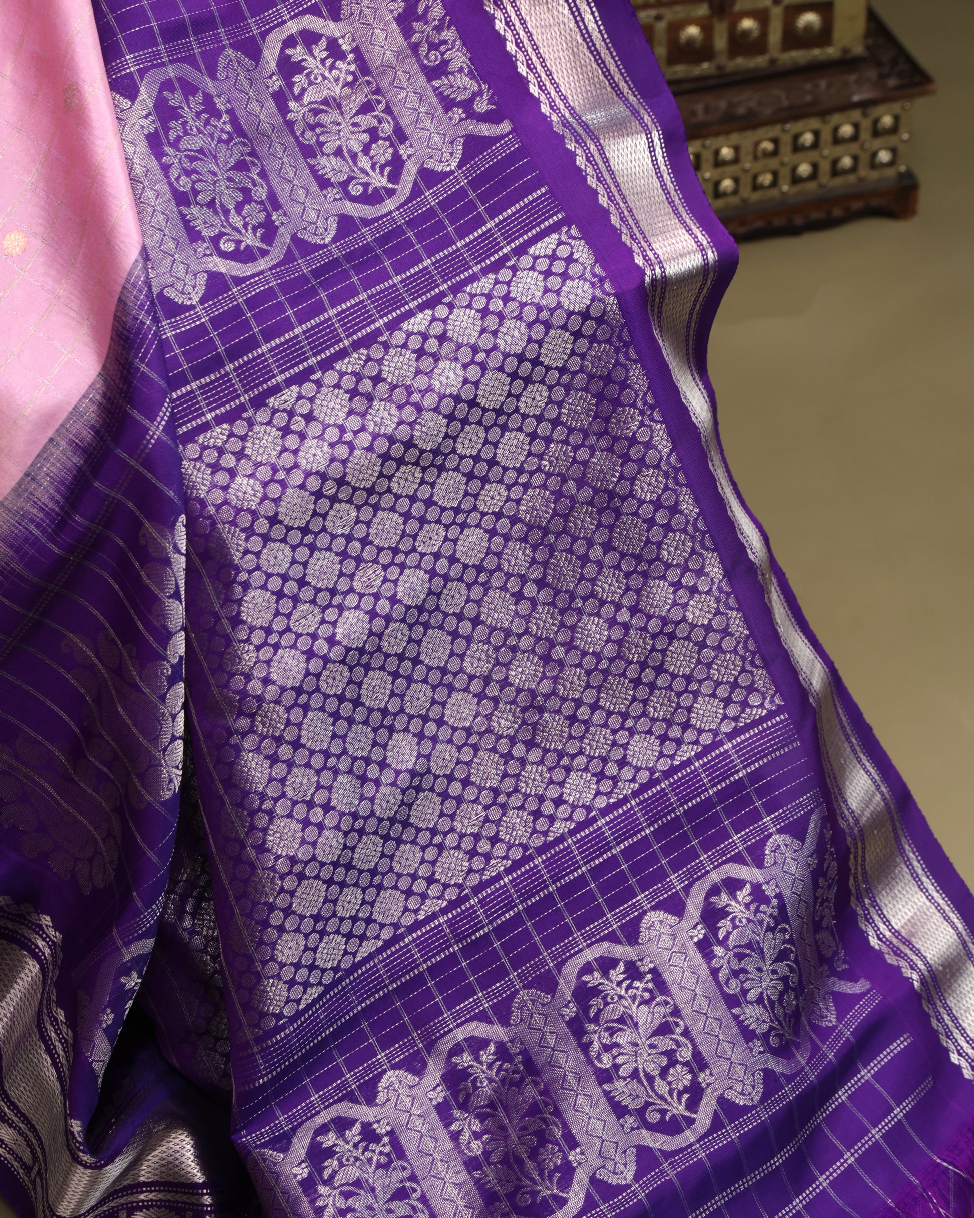 Elegant light pink silk saree with silver zari detailing and purple pallu