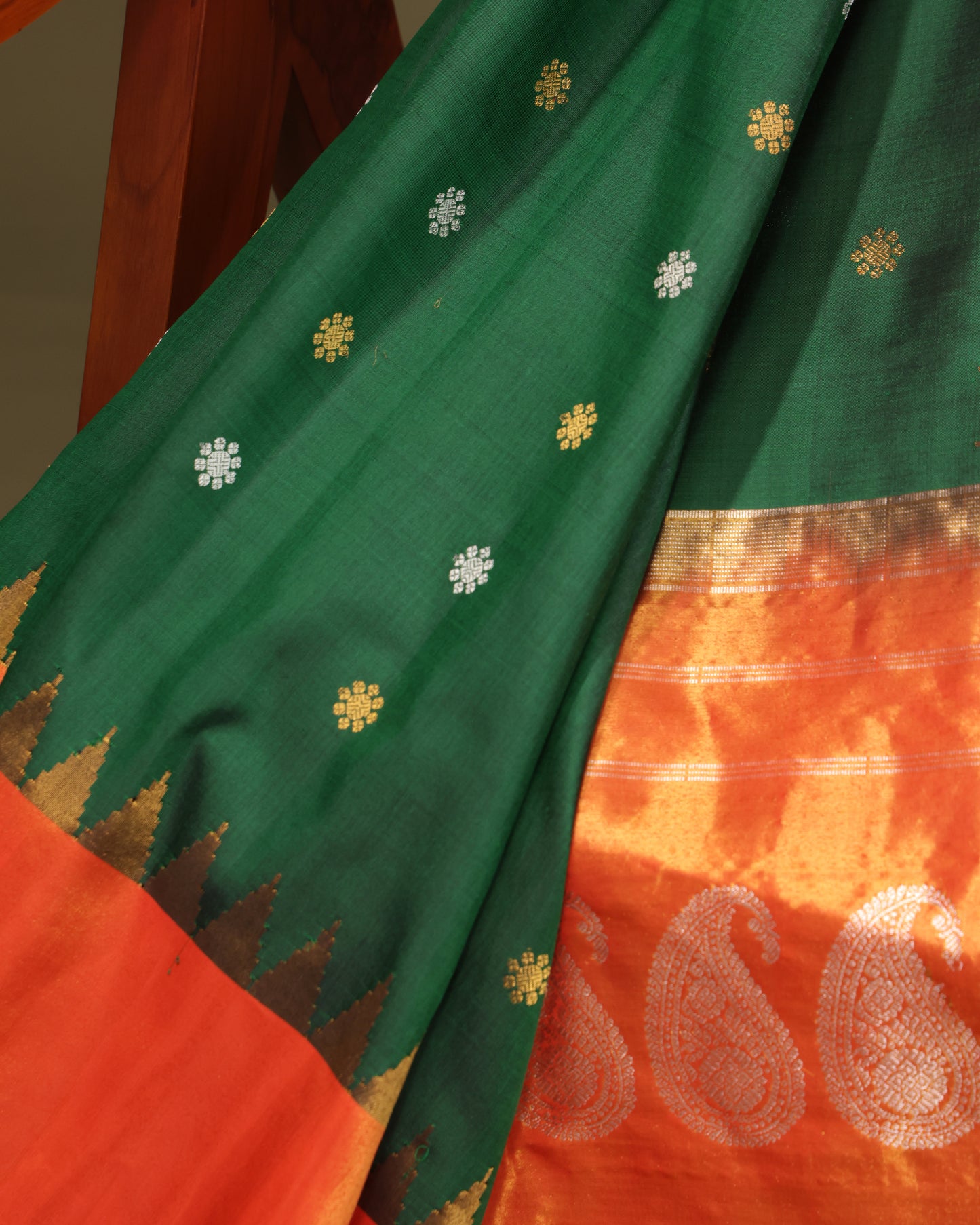Green silk saree featuring zari detailing and orange tissue border