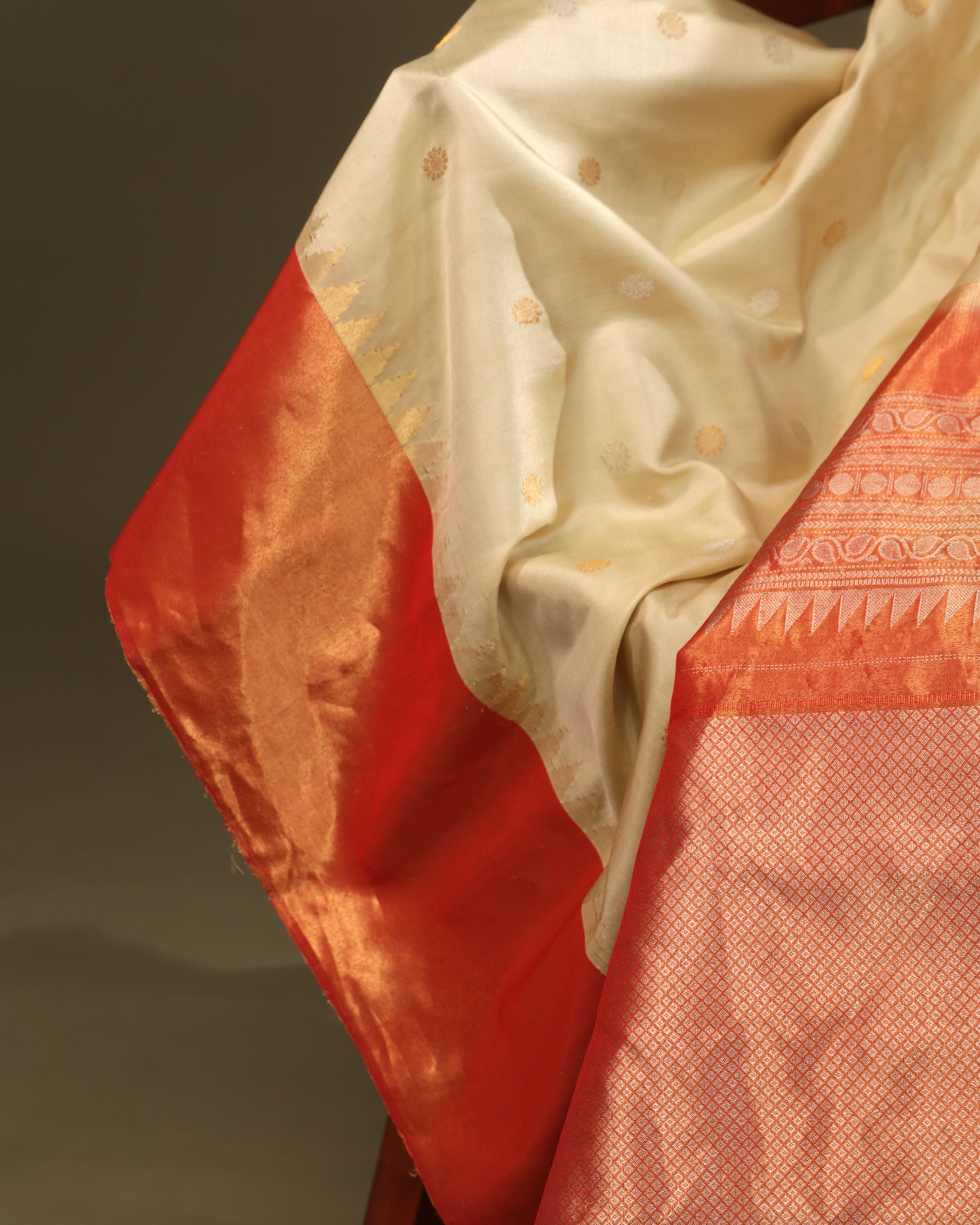 Cream silk saree with delicate buttas and orange tissue detailing