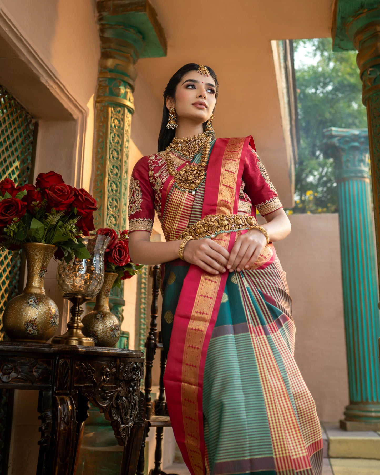 Handwoven bridal saree in teal green with golden zari work and rich red border
