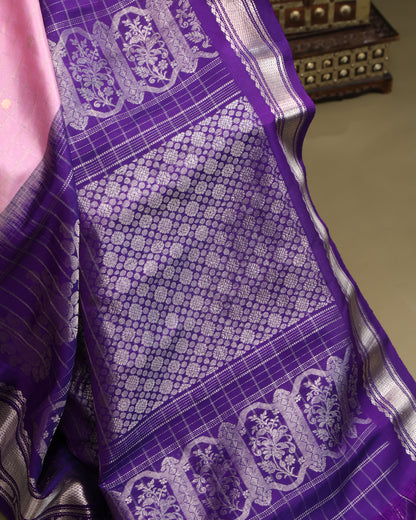 Elegant light pink silk saree with silver zari detailing and purple pallu